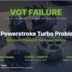 Disassembled 6.7 Powerstroke Garrett variable geometry turbocharger laid out on a stainless workbench — billet and stock compressor wheels, a heavily carbon-fouled turbine wheel with stuck VGT vane debris, the center bearing housing, and the cast iron turbine housing